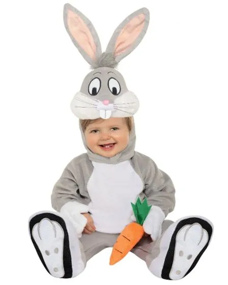 Smiling baby dressed in a grey and white Bugs Bunny costume with an attached hood featuring a cartoon bunny face and long ears, holding a plush carrot.